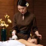 A professional massage therapist is currently providing service to a customer.